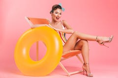 Женщина изолированная на шезлонге с раздувным кольцом Стоковая Фотография RF Женщина изолированная на шезлонге с раздувным кольцом Стоковая Фотография RF