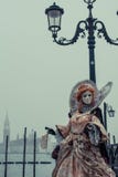 Женщина одетая с костюмом на день масленицы в улицах Венеции около квадрата St Mark стоковое фото rf Женщина одетая с костюмом на день масленицы в улицах Венеции около квадрата St Mark стоковое фото rf