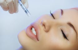 Женщина получая впрыску в ее губах в салоне красоты Стоковые Фотографии RF Женщина получая впрыску в ее губах в салоне красоты Стоковые Фотографии RF