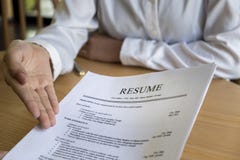 Женщина представляет заявление о приеме на работу, интервьюер читая резюме стоковое изображение rf Женщина представляет заявление о приеме на работу, интервьюер читая резюме стоковое изображение rf