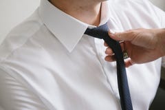 Женщина связывая черный галстук вокруг шеи человека стоковые изображения rf Женщина связывая черный галстук вокруг шеи человека стоковые изображения rf