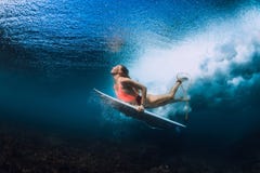 Женщина серфера с пикированием surfboard подводным стоковые фотографии rf Женщина серфера с пикированием surfboard подводным стоковые фотографии rf