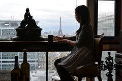 Женщина сидя во французской комнате стиля в Париже, предпосылке Эйфелева башня, Франция стоковое изображение rf Женщина сидя во французской комнате стиля в Париже, предпосылке Эйфелева башня, Франция стоковое изображение rf