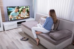Женщина смотря телевидение дома стоковое фото Женщина смотря телевидение дома стоковое фото