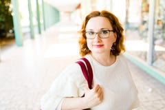 Женщина со стеклами представляя в колоннаде стоковое изображение rf Женщина со стеклами представляя в колоннаде стоковое изображение rf