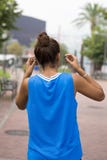 Женщина спортсмена вниз к наушникам перед работать, внешний стоковые изображения Женщина спортсмена вниз к наушникам перед работать, внешний стоковые изображения
