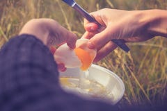 Женщина треская яичко на портативной располагаясь лагерем плите Стоковое Фото Женщина треская яичко на портативной располагаясь лагерем плите Стоковое Фото
