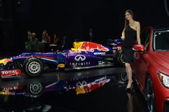 Женщины в черном платье от Infiniti объединяются в команду около автомобиля салон автомобиля Москвы красного Bull и красного авто Стоковые Изображения RF Женщины в черном платье от Infiniti объединяются в команду около автомобиля салон автомобиля Москвы красного Bull и красного авто Стоковые Изображения RF