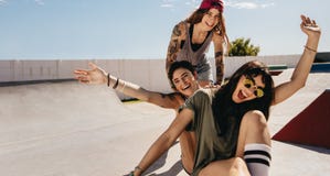 Женщины на коньке паркуют иметь потеху с скейтбордом Стоковая Фотография Женщины на коньке паркуют иметь потеху с скейтбордом Стоковая Фотография