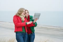 2 женщины наслаждаются цифровой таблеткой на природе Стоковая Фотография RF