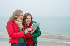 2 женщины наслаждаются цифровой таблеткой на природе Стоковая Фотография