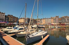Живописная старая гавань на деревне Нормандии Honfleur Франции с шлюпками, яхтами, кафами и морем на солнечный весенний день стоковые фотографии rf Живописная старая гавань на деревне Нормандии Honfleur Франции с шлюпками, яхтами, кафами и морем на солнечный весенний день стоковые фотографии rf