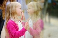 Животные милой маленькой девочки наблюдая на зоопарке на теплый и солнечный летний день Животные зоопарка ребенка наблюдая через стоковая фотография Животные милой маленькой девочки наблюдая на зоопарке на теплый и солнечный летний день Животные зоопарка ребенка наблюдая через стоковая фотография