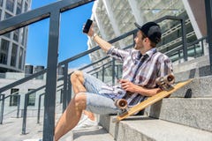 Жизнерадостный мужской конькобежец фотографируя на телефоне стоковое изображение Жизнерадостный мужской конькобежец фотографируя на телефоне стоковое изображение