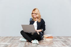 Жизнерадостный студент молодой женщины используя портативный компьютер Стоковые Фото Жизнерадостный студент молодой женщины используя портативный компьютер Стоковые Фото