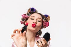 Жизнерадостная домохозяйка с curlers в робе волос нося стоковые фотографии rf Жизнерадостная домохозяйка с curlers в робе волос нося стоковые фотографии rf