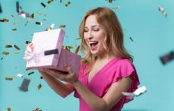 Жизнерадостная подарочная коробка отверстия девушки с интересом стоковое фото rf Жизнерадостная подарочная коробка отверстия девушки с интересом стоковое фото rf