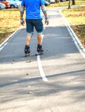 Жизнерадостный sporty человек 50-55 лет едущ кататься на коньках ролика в парке в сезоне осени, rollerblading как здоровая тренир стоковые фотографии rf Жизнерадостный sporty человек 50-55 лет едущ кататься на коньках ролика в парке в сезоне осени, rollerblading как здоровая тренир стоковые фотографии rf