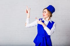 Жизнерадостный stewardess в голубой крышке делает жесты с ее руками стоковые изображения Жизнерадостный stewardess в голубой крышке делает жесты с ее руками стоковые изображения