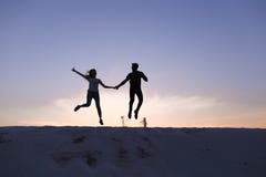 Жизнерадостный парень и девушка имея потеху и танцуя na górze песчанной дюны стоковая фотография rf Жизнерадостный парень и девушка имея потеху и танцуя na górze песчанной дюны стоковая фотография rf