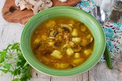 Здоровый суп с гречихой, картошкой, грибами, морковами и oi острословия лука прованским в зеленом шаре на деревянной предпосылке стоковые изображения rf Здоровый суп с гречихой, картошкой, грибами, морковами и oi острословия лука прованским в зеленом шаре на деревянной предпосылке стоковые изображения rf