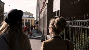 Задний взгляд молодой творческой женщины 2 идя в центр города и говорить Творческие архитекторы обсуждая проект сток-видео Задний взгляд молодой творческой женщины 2 идя в центр города и говорить Творческие архитекторы обсуждая проект сток-видео