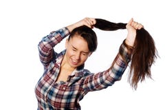 Забавная жизнерадостная девушка держа ее длинные волосы в ponytail над белой предпосылкой стоковая фотография rf Забавная жизнерадостная девушка держа ее длинные волосы в ponytail над белой предпосылкой стоковая фотография rf