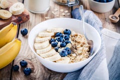 Завтрак: овсяная каша с бананами, голубиками, семенами chia и миндалинами стоковые фото Завтрак: овсяная каша с бананами, голубиками, семенами chia и миндалинами стоковые фото