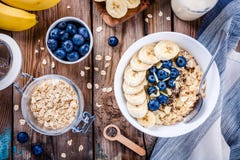 Завтрак: овсяная каша с бананами, голубиками, семенами chia и миндалинами стоковые изображения Завтрак: овсяная каша с бананами, голубиками, семенами chia и миндалинами стоковые изображения