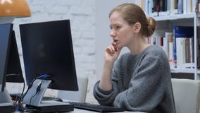 Задумчивая молодая женщина потревожилась о ее проекте, сидя в офисе стоковая фотография Задумчивая молодая женщина потревожилась о ее проекте, сидя в офисе стоковая фотография