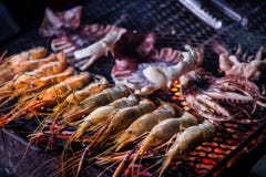 Зажаренные королевские креветки и кальмар на огне bbq Тайская еда улицы на рынке ночи города Чиангмая старом Таиланд стоковое изображение Зажаренные королевские креветки и кальмар на огне bbq Тайская еда улицы на рынке ночи города Чиангмая старом Таиланд стоковое изображение