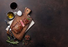 Зажаренный стейк говядины ribeye с красным вином, травами и специями стоковые фото Зажаренный стейк говядины ribeye с красным вином, травами и специями стоковые фото