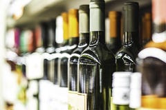 Закройте вверх бутылок вина на полке в магазине стоковое изображение rf Закройте вверх бутылок вина на полке в магазине стоковое изображение rf