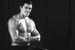 Закройте вверх весов молодого мышечного человека поднимаясь над темнотой стоковые фото Закройте вверх весов молодого мышечного человека поднимаясь над темнотой стоковые фото
