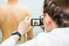 Закройте вверх по женскому физиотерапевту в ее практике, сделайте фотосессию из мужской pacient задней части ` s стоковая фотография rf Закройте вверх по женскому физиотерапевту в ее практике, сделайте фотосессию из мужской pacient задней части ` s стоковая фотография rf