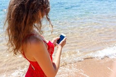 Закройте вверх по женщине отправляя СМС в умном телефоне на пляже Море на заднем плане стоковое фото Закройте вверх по женщине отправляя СМС в умном телефоне на пляже Море на заднем плане стоковое фото