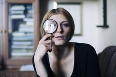 Закройте вверх по портрету красивой женщины с стеклянным увеличителем Стоковая Фотография RF Закройте вверх по портрету красивой женщины с стеклянным увеличителем Стоковая Фотография RF