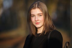 Закройте вверх по эмоциональному портрету молодой счастливой красивой женщины при немножко улыбка нося черное пальто представляя стоковое фото rf Закройте вверх по эмоциональному портрету молодой счастливой красивой женщины при немножко улыбка нося черное пальто представляя стоковое фото rf