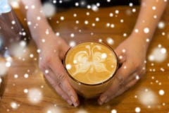 Закройте вверх рук с искусством latte в кофейной чашке стоковое фото rf Закройте вверх рук с искусством latte в кофейной чашке стоковое фото rf