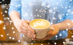 Закройте вверх рук с искусством latte в кофейной чашке стоковые изображения Закройте вверх рук с искусством latte в кофейной чашке стоковые изображения