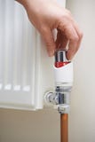 Закройте вверх руки регулируя термостат топления стоковые фотографии rf Закройте вверх руки регулируя термостат топления стоковые фотографии rf