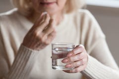Закройте вверх таблетки старшего чувства женщины нездоровой принимая стоковые изображения rf Закройте вверх таблетки старшего чувства женщины нездоровой принимая стоковые изображения rf