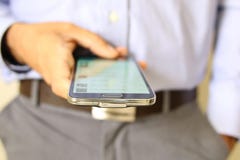 Закройте вверх человека используя передвижной умный телефон стоковое изображение Закройте вверх человека используя передвижной умный телефон стоковое изображение