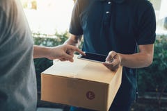 Закройте вверх человека руки азиатского используя смартфон отжимая экран подписать для доставки от курьера дома стоковые фото Закройте вверх человека руки азиатского используя смартфон отжимая экран подписать для доставки от курьера дома стоковые фото