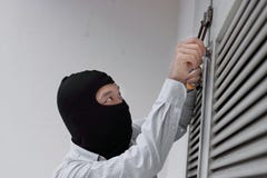 Замаскированный разбойник используя инструмент рудоразборки замка к взлому и проникновение в дом Уголовная концепция злодеяния стоковое фото Замаскированный разбойник используя инструмент рудоразборки замка к взлому и проникновение в дом Уголовная концепция злодеяния стоковое фото