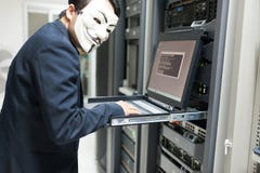Замаскированный хакер в концепции комнаты сервера компьютера Стоковые Фото Замаскированный хакер в концепции комнаты сервера компьютера Стоковые Фото
