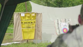 Запачкайте назад взгляд стрельбы человека на желтой цели при животные нарисованные на ей Человек на правильной позиции видеоматериал Запачкайте назад взгляд стрельбы человека на желтой цели при животные нарисованные на ей Человек на правильной позиции видеоматериал