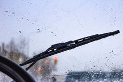 Запачкано грязное лобовое стекло автомобиля с включенным стеклянным уборщиком, в больших фронте города и задней части предпосылки стоковые изображения Запачкано грязное лобовое стекло автомобиля с включенным стеклянным уборщиком, в больших фронте города и задней части предпосылки стоковые изображения