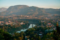 Заход солнца в Lunag Prabang, Лаосе Красивые облака над городом Меконг между деревьями и домами Зима в Лаосе стоковые изображения rf Заход солнца в Lunag Prabang, Лаосе Красивые облака над городом Меконг между деревьями и домами Зима в Лаосе стоковые изображения rf