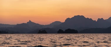 Заход солнца в горах и море стоковые изображения rf Заход солнца в горах и море стоковые изображения rf